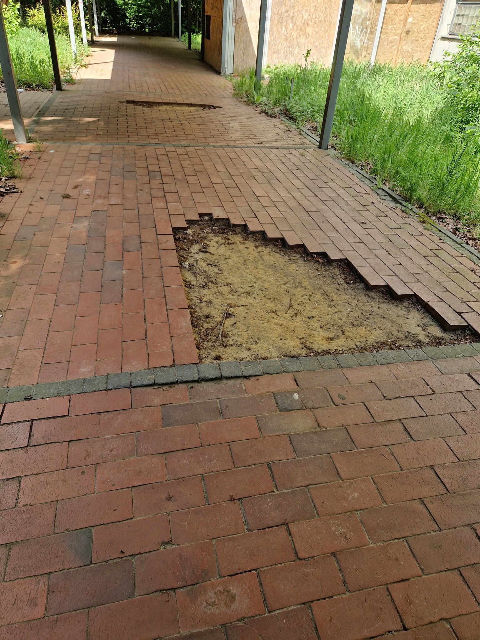 Fehlende rote Pflastersteine im überdachten Gang der ehemaligen GHS; Aufnahme vor Installation der Kameras.